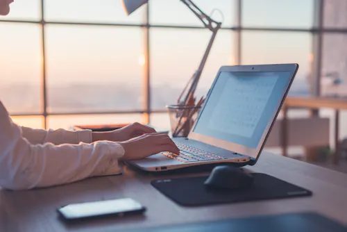 Adult learner typing at laptop