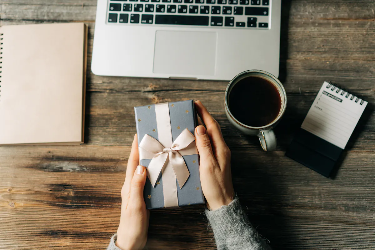 Gift box beside laptop and coffee