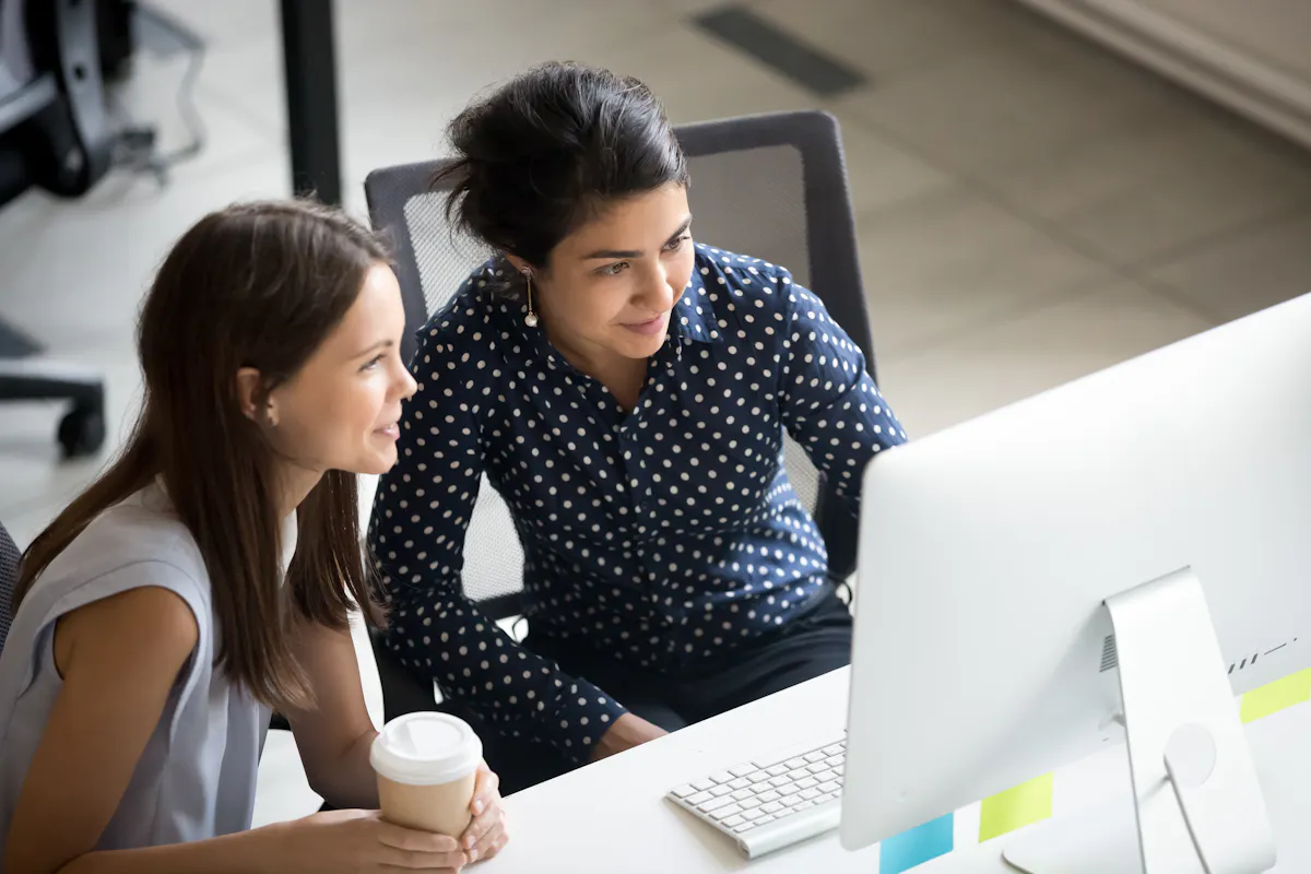 Two women looking at desktop together