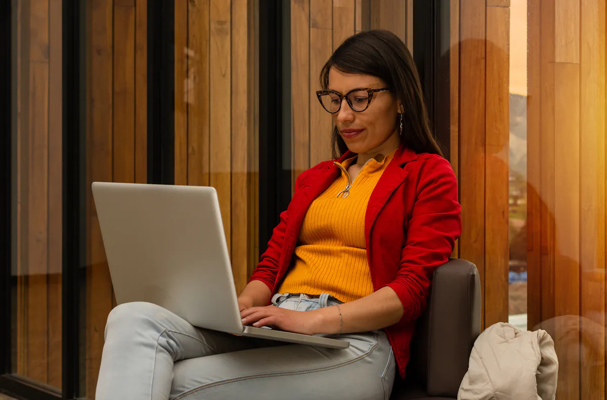 Woman in red and yellow working at laptop