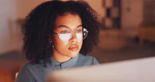 Woman thinking at computer screen