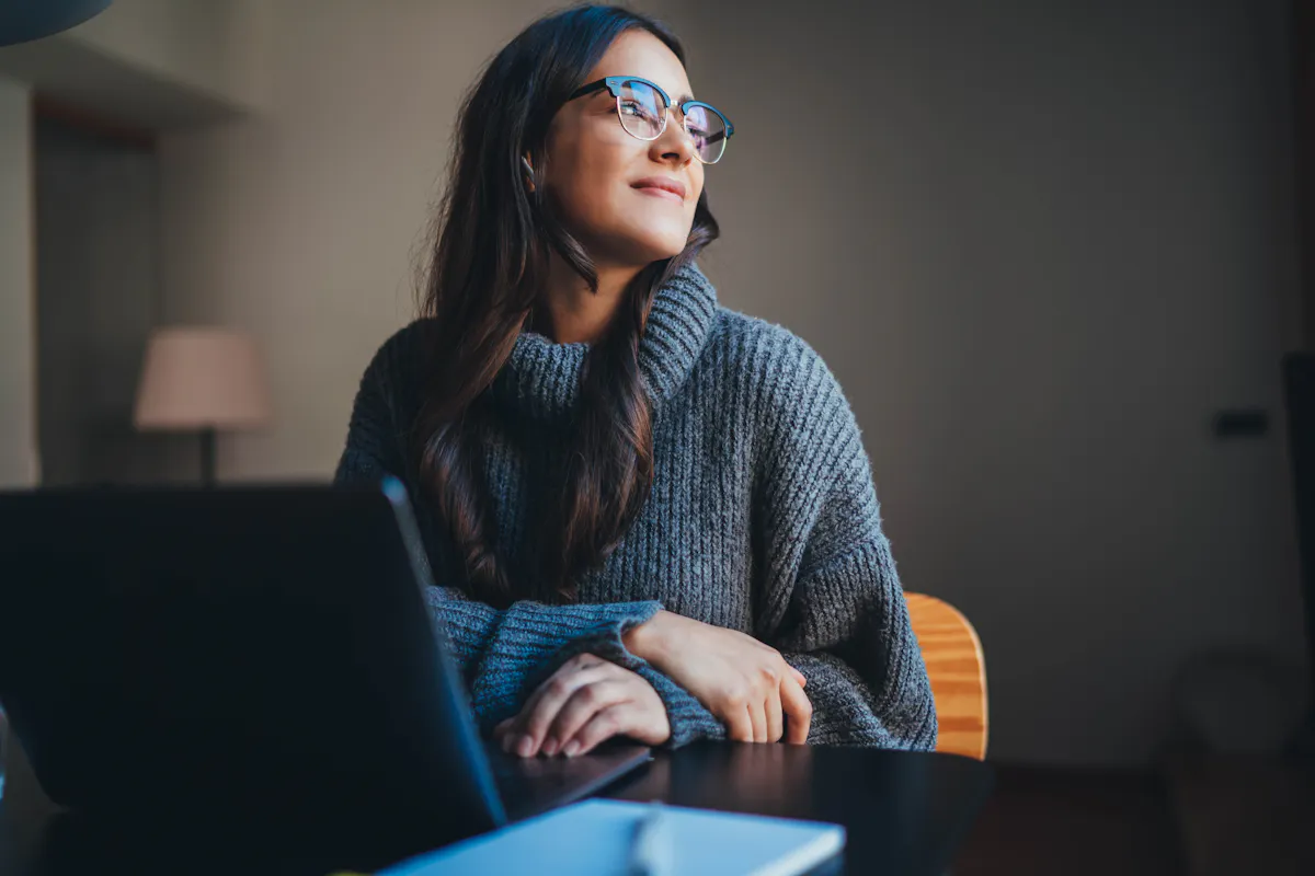 Woman wearing glasses smiling looking out window