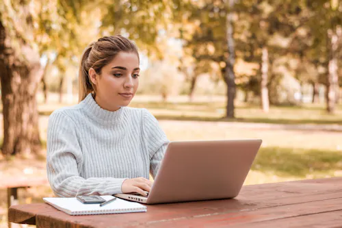 Woman working on her computer outside