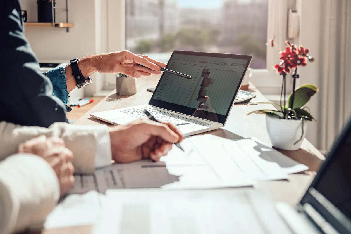 A product owner reviews a project timeline on a laptop.