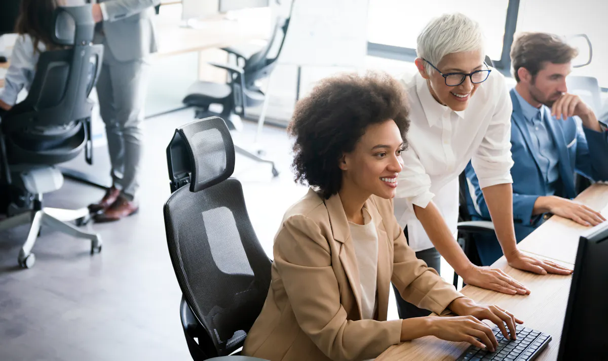 A product manager and software engineer review a software product on a monitor.