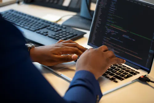 A coder works on a laptop.