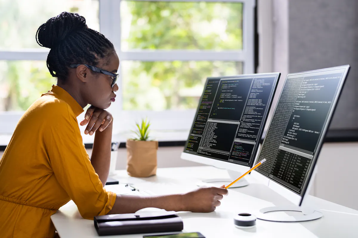 A software engineer reviews code on a monitor.