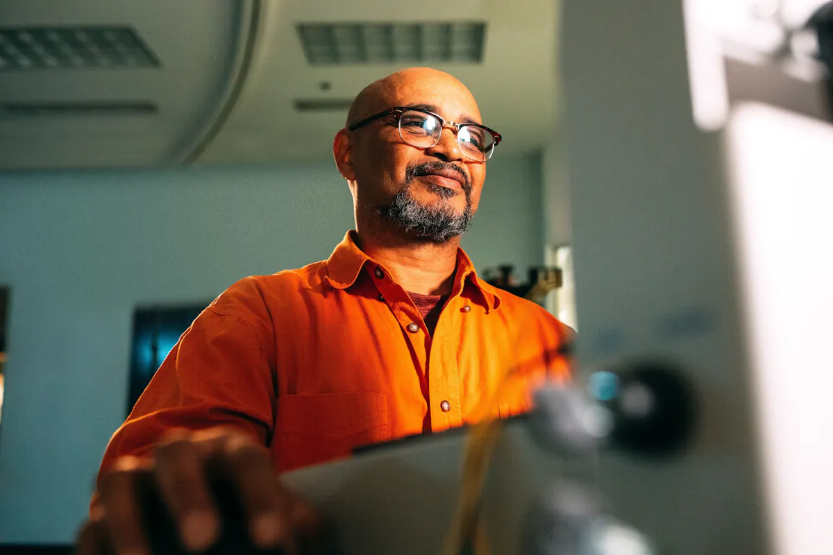 Man in orange looking at screen