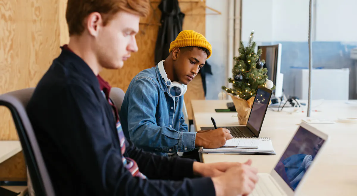 Two guys working on code at a desk