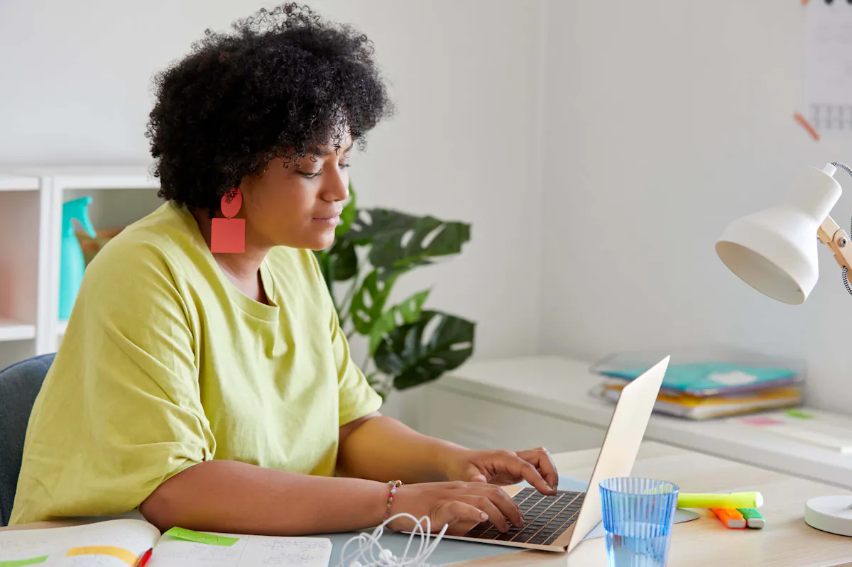 Woman in green working on laptop