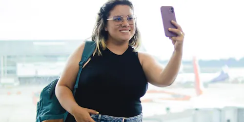 Woman looking at her phone while in the airport traveling