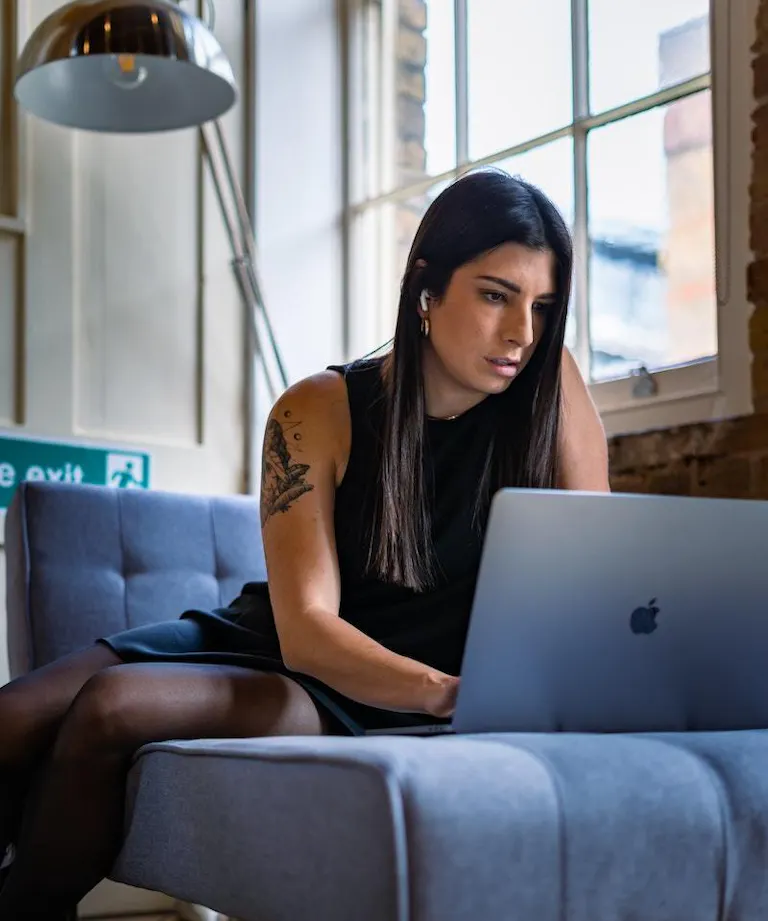 Woman studying from couch on mac