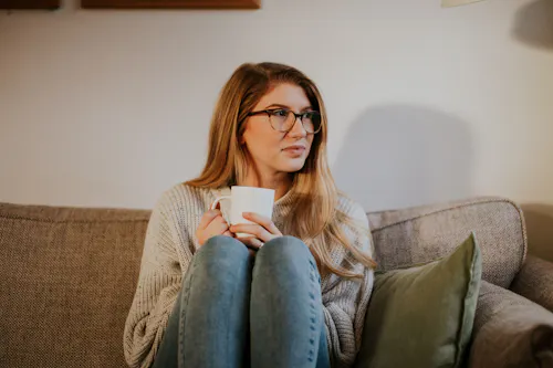 Women in glasses with coffee thinking